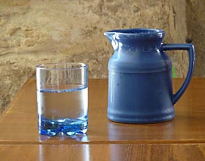 Blauwe kan met glas water
